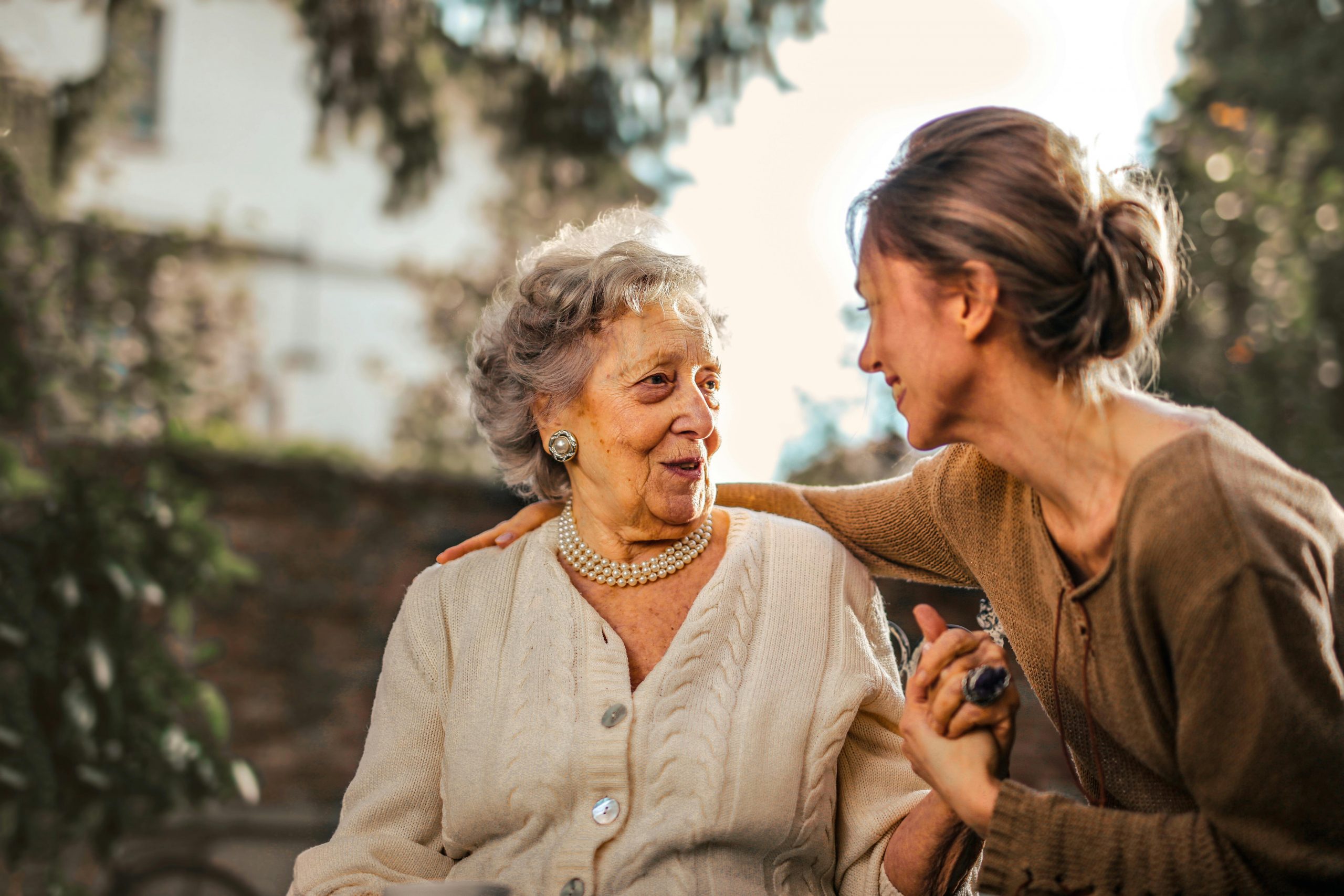 An older woman speaking with a younger woman who are having a conversation, used to explain when to stop mammograms
